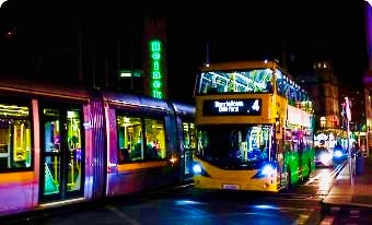 Image of a Dublin Bus and Luas in the city at night