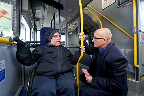 Image of dublin bus employee talking to wheelchair user on the bus