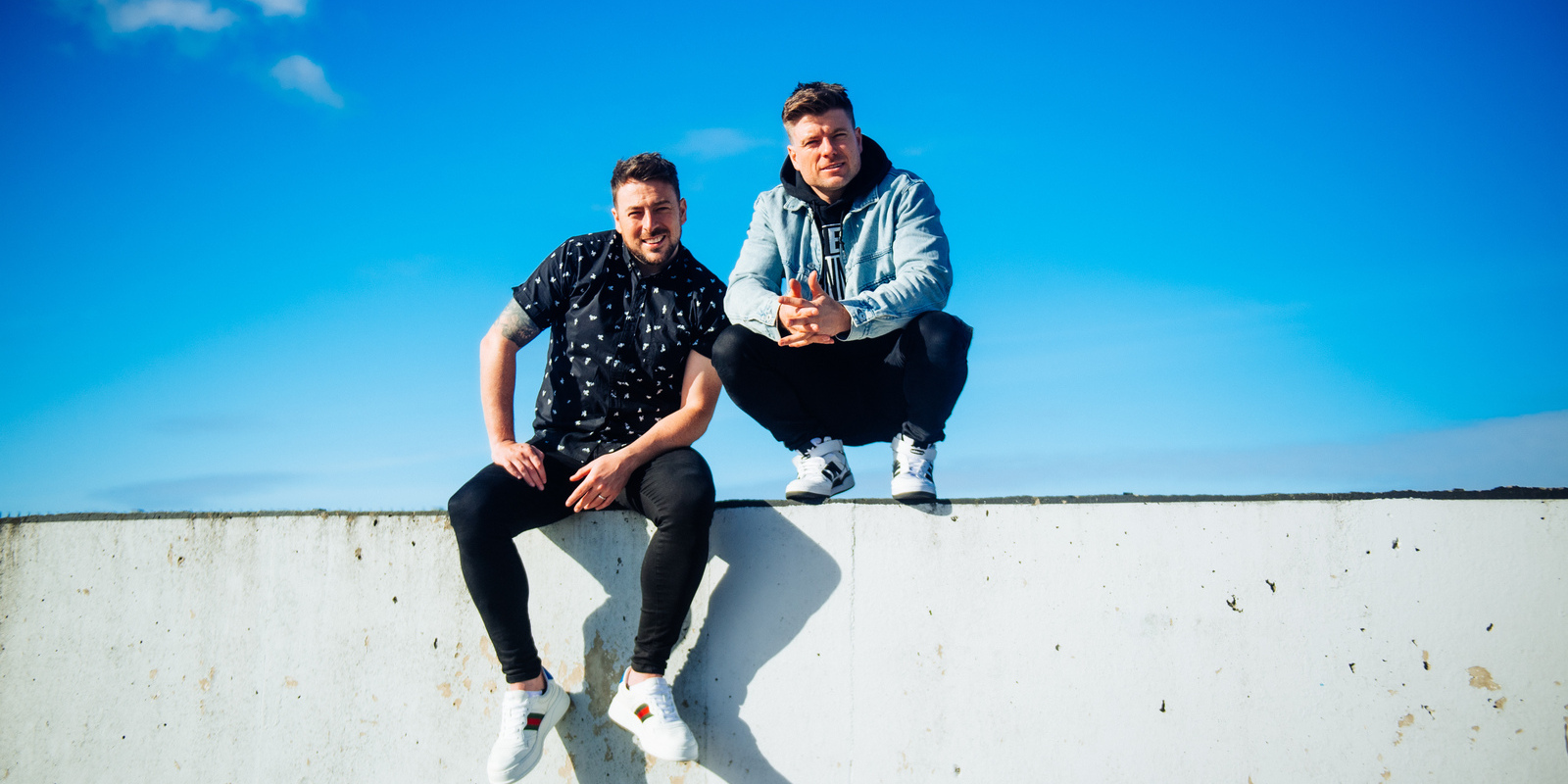 Image of the two Johnnies sitting on a wall