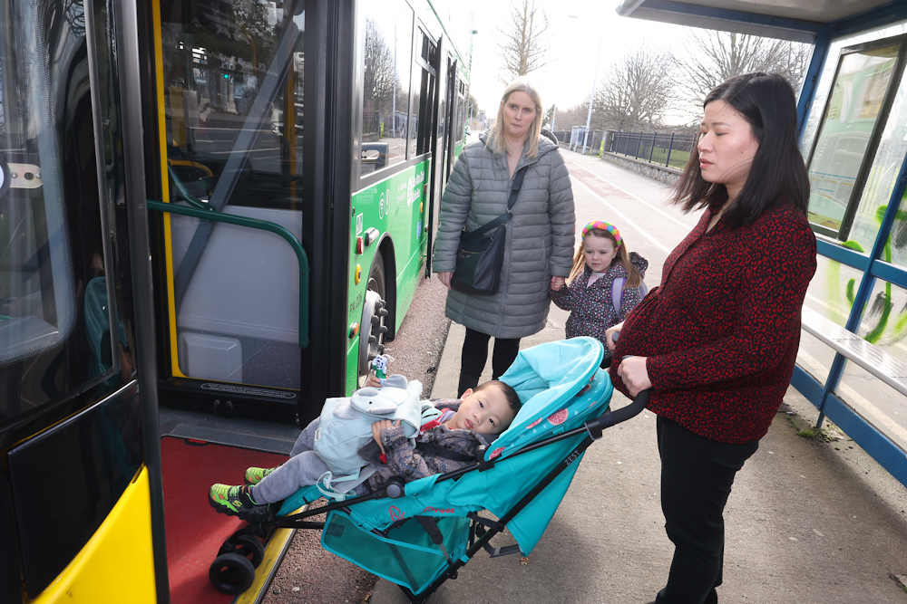 Woman boarding bus with buggy