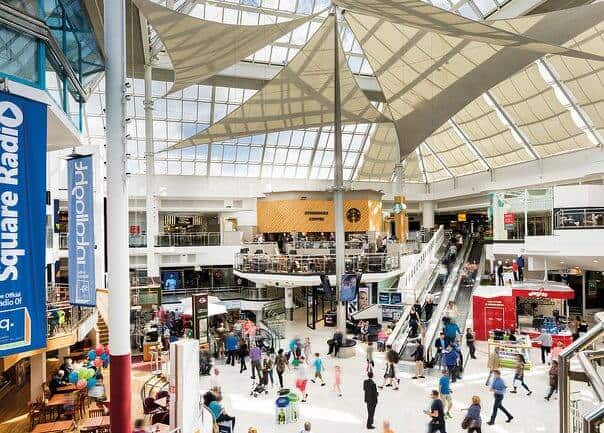 Image of inside The Square shopping and with shopping bags.