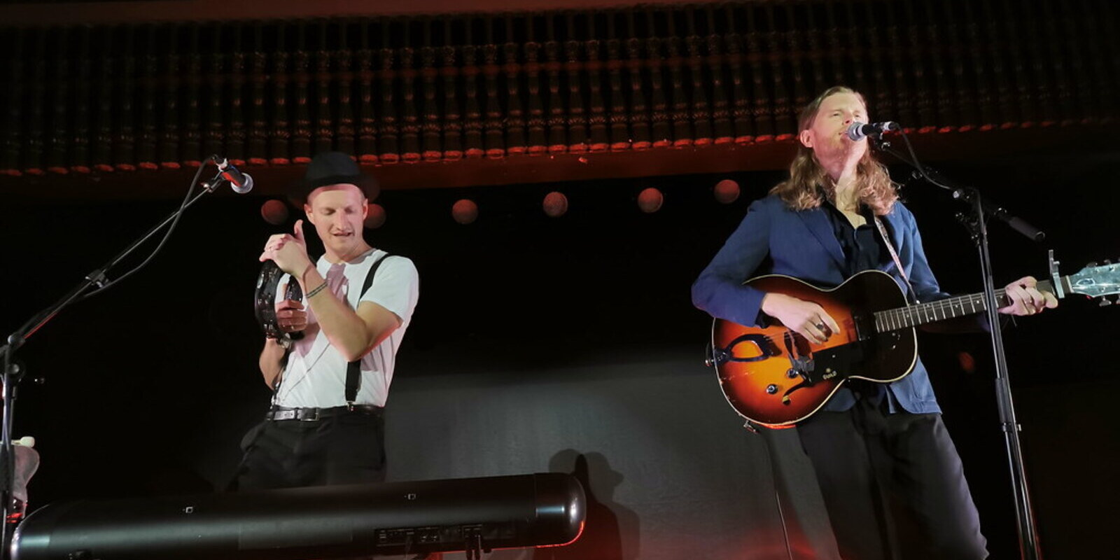 Image of two male musicians on stage from the band The Lumineers 