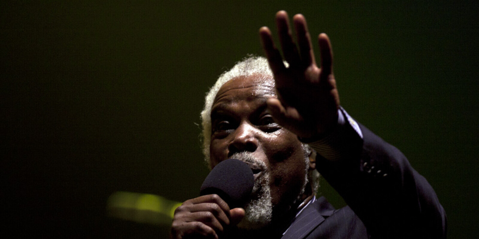 Image of male musician on stage with microphone, Billy Ocean who will play at the Rewind Festival